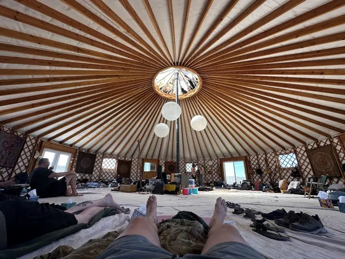 Participants resting on mats beneath the wooden ceiling of the retreat yurt