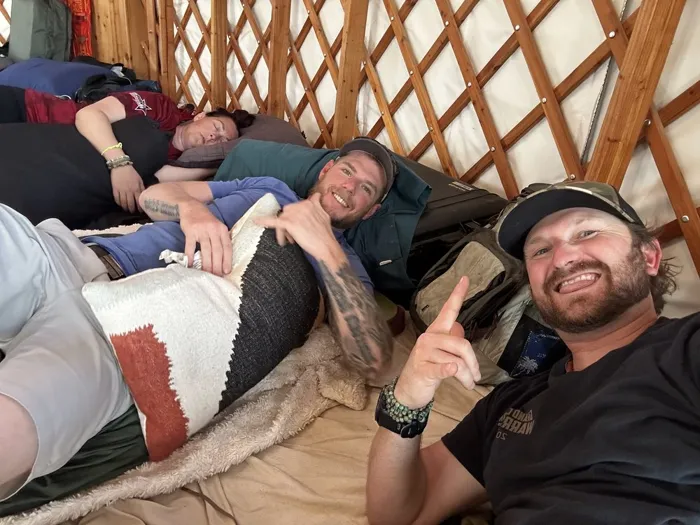Veterans laughing together while resting side by side in the yurt