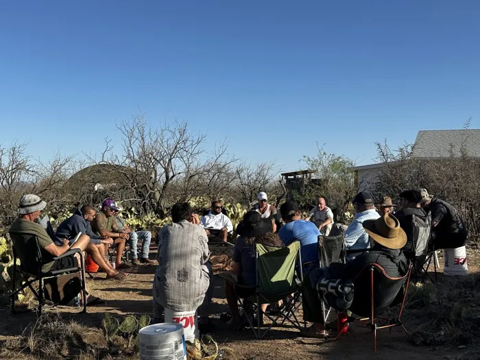 The full cohort gathered in an evening circle under desert trees